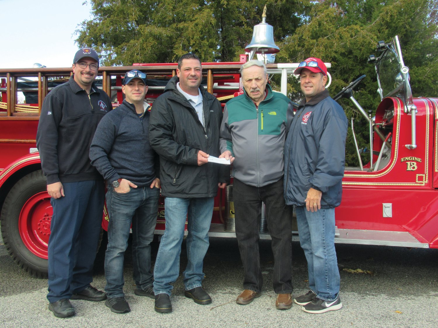 HISTORIC HAPPENING: Former JFD Chief Alan Zambarano presents JFD Lt. Jon Pistacchio with a check from the former Johnston Hose  Volunteer Company No. 1 that local 1950 will use in its continuing giving back to the community. Also taking part were Firefighters Scott Thacker, Chris DelFino and Lt. David Pingitore.